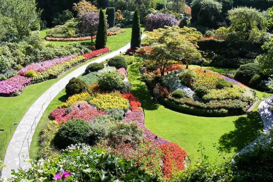 A professionally landscaped garden with layered planting beds and a mowed lawn.